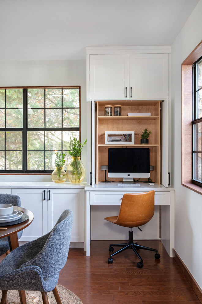 Imagen de despacho tradicional renovado pequeño con suelo de madera oscura, paredes blancas, escritorio empotrado y suelo marrón