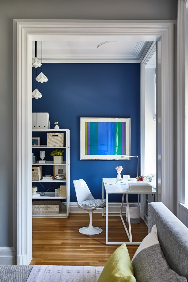 На фото: кабинет в стиле неоклассика (современная классика) с синими стенами, паркетным полом среднего тона, отдельно стоящим рабочим столом и коричневым полом