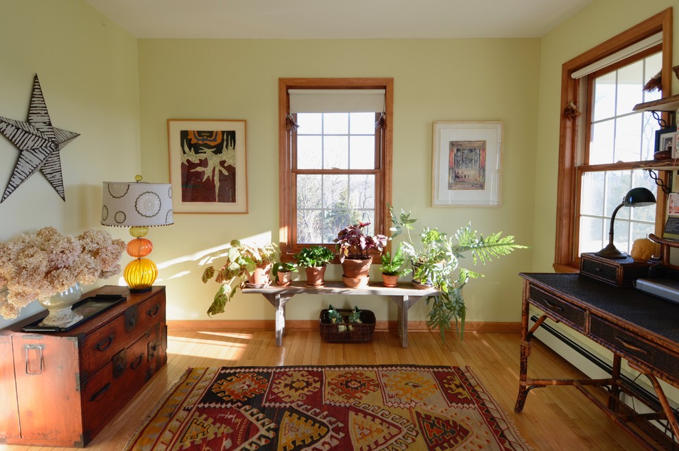 Foto på ett litet eklektiskt arbetsrum, med gröna väggar, ljust trägolv och ett fristående skrivbord