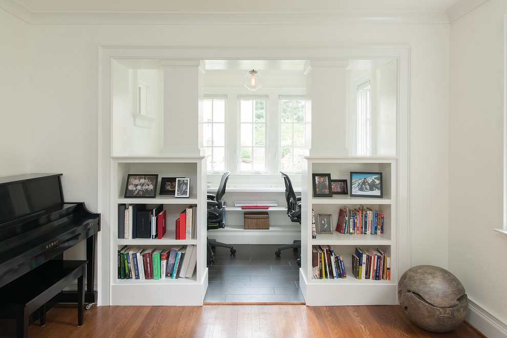This is an example of a small classic study in DC Metro with white walls, slate flooring, a built-in desk and black floors.