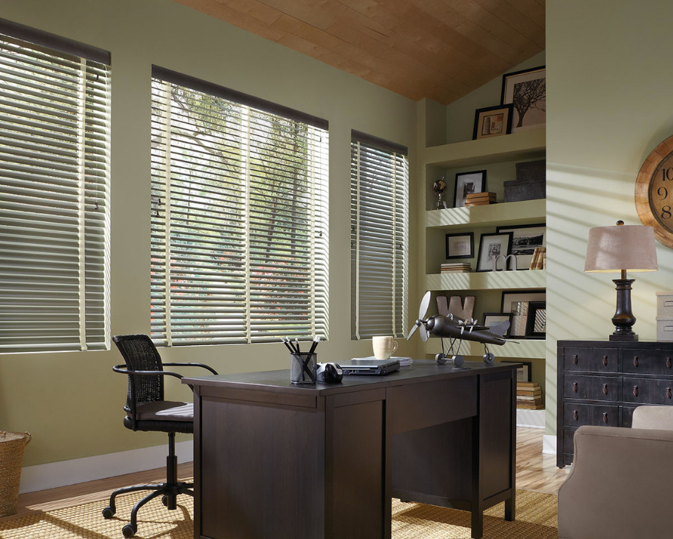 Diseño de despacho clásico grande sin chimenea con paredes beige, suelo de madera clara, escritorio independiente y suelo marrón