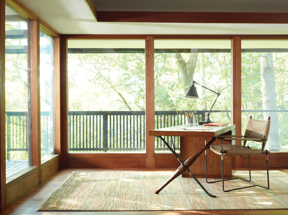 Cette image montre un bureau design de taille moyenne avec un mur marron, un sol en bois brun, aucune cheminée, un bureau indépendant et un sol marron.