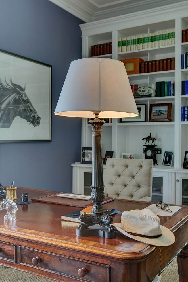 Modelo de despacho tradicional renovado grande con paredes azules, suelo de madera en tonos medios y escritorio independiente