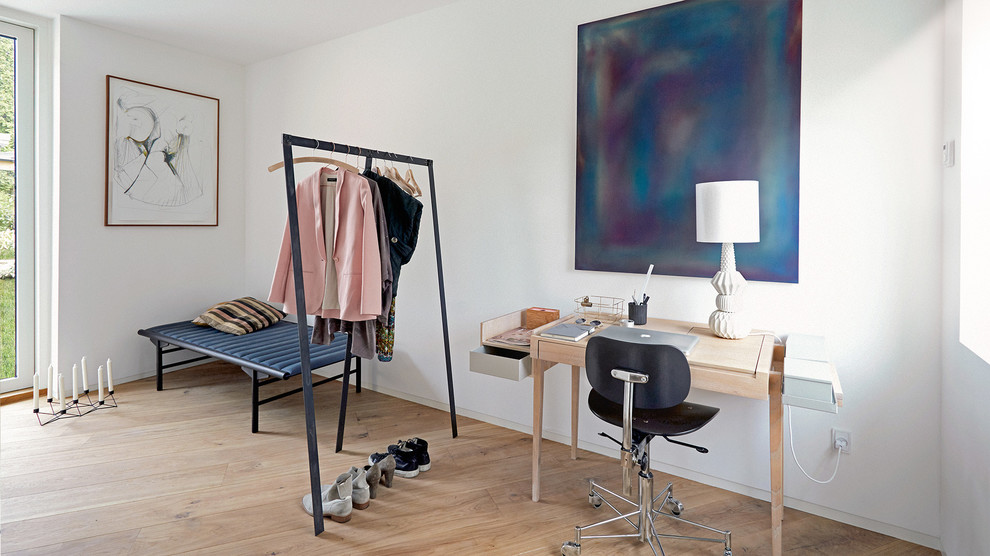 Photo of a small scandi home studio in Copenhagen with white walls, light hardwood flooring and a freestanding desk.