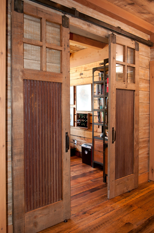 На фото: кабинет среднего размера в стиле рустика с коричневыми стенами, темным паркетным полом и встроенным рабочим столом без камина с