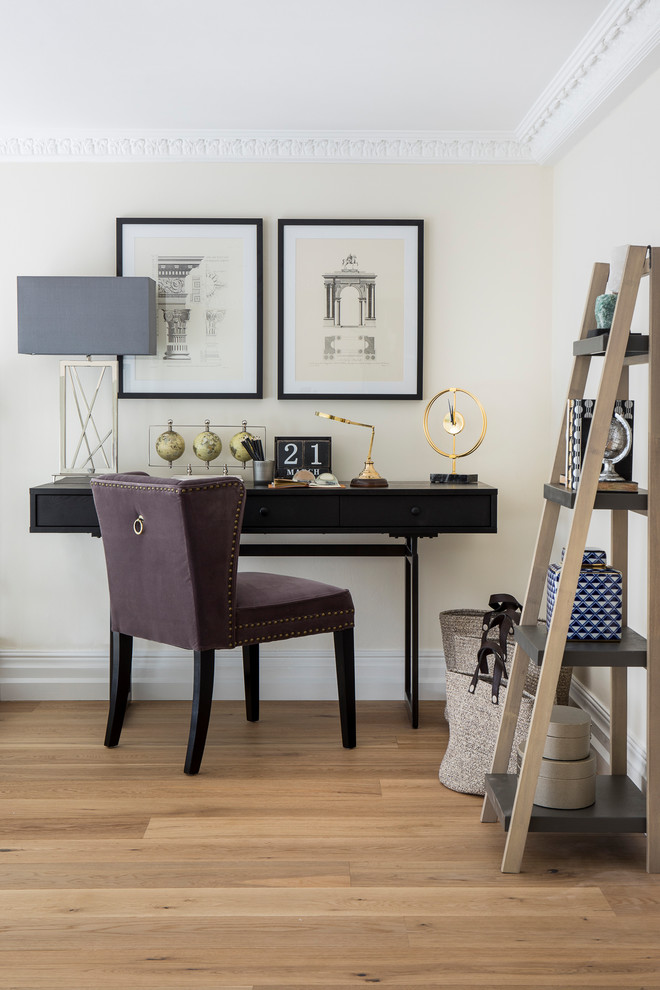 Klassisches Arbeitszimmer mit Arbeitsplatz, beiger Wandfarbe, hellem Holzboden und freistehendem Schreibtisch in London