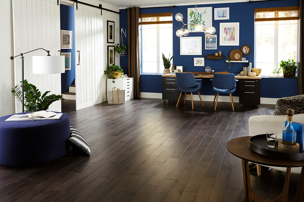 Imagen de despacho ecléctico grande con paredes azules, suelo de madera oscura, escritorio independiente y suelo marrón