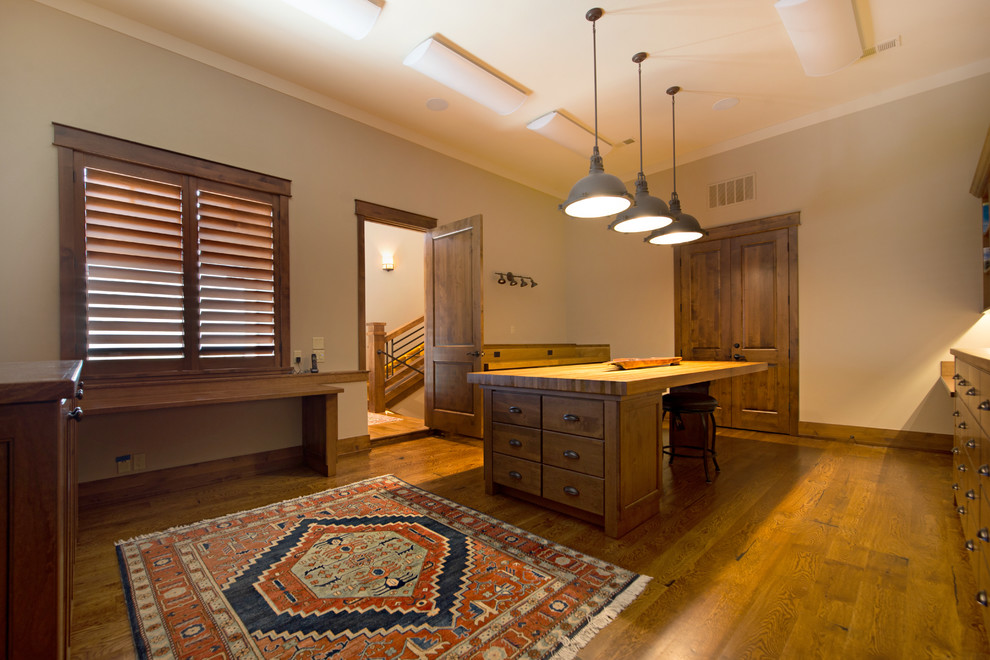 Cette photo montre un grand bureau craftsman avec un mur blanc, un sol en bois brun, aucune cheminée et un bureau intégré.