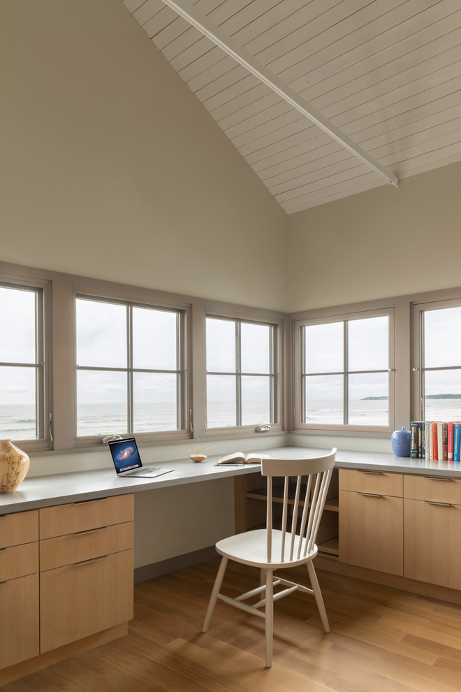 Design ideas for a coastal home office in Portland Maine with beige walls, medium hardwood flooring, a built-in desk and brown floors.