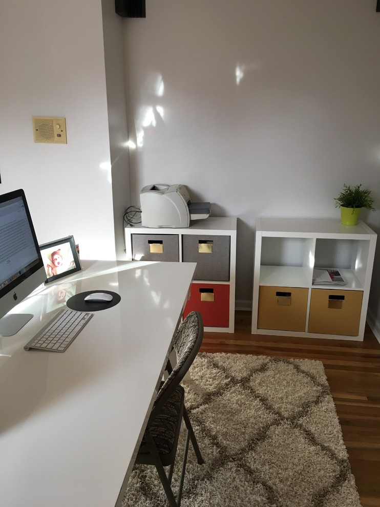 Idee per uno studio classico di medie dimensioni con pavimento in legno massello medio e scrivania autoportante