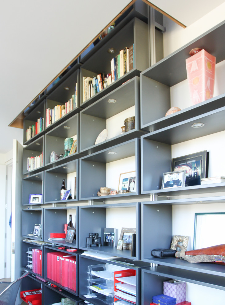 Cette image montre un grand bureau minimaliste avec une bibliothèque ou un coin lecture, un mur blanc, parquet clair et un bureau indépendant.
