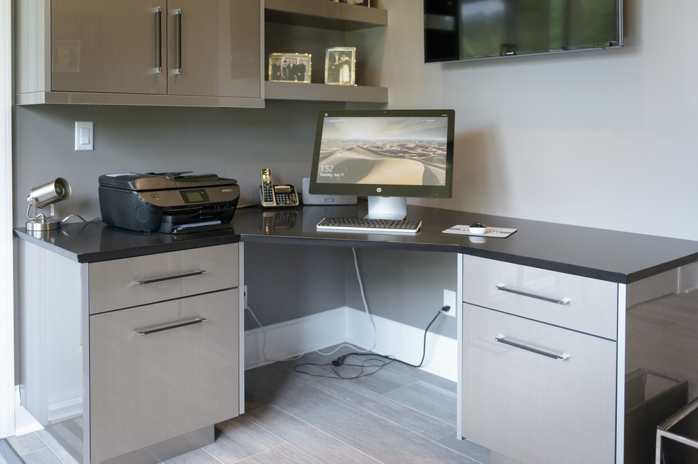 Foto de despacho actual pequeño con paredes grises, suelo de baldosas de porcelana, suelo marrón y escritorio empotrado