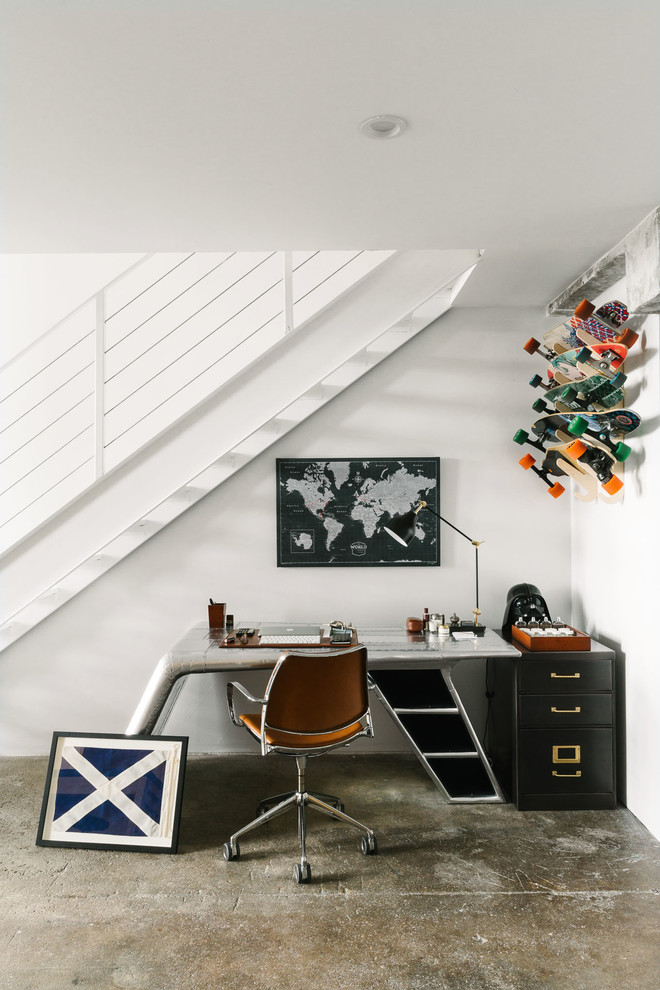Industrial Arbeitszimmer mit weißer Wandfarbe, Betonboden, freistehendem Schreibtisch und grauem Boden in Sonstige