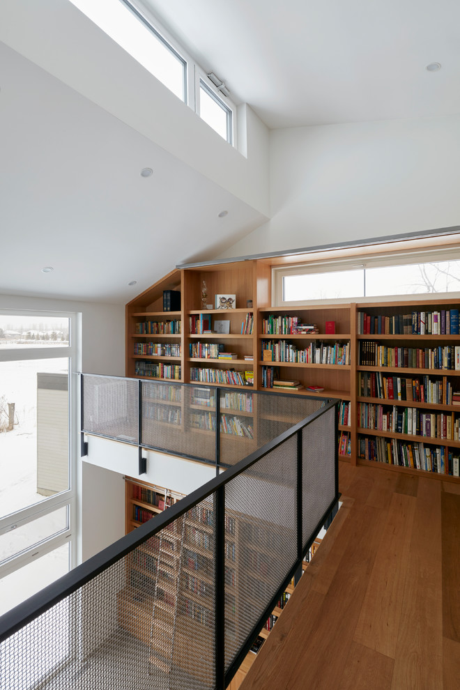 Пример оригинального дизайна: огромный домашняя библиотека в стиле модернизм с белыми стенами, бетонным полом, встроенным рабочим столом и серым полом без камина
