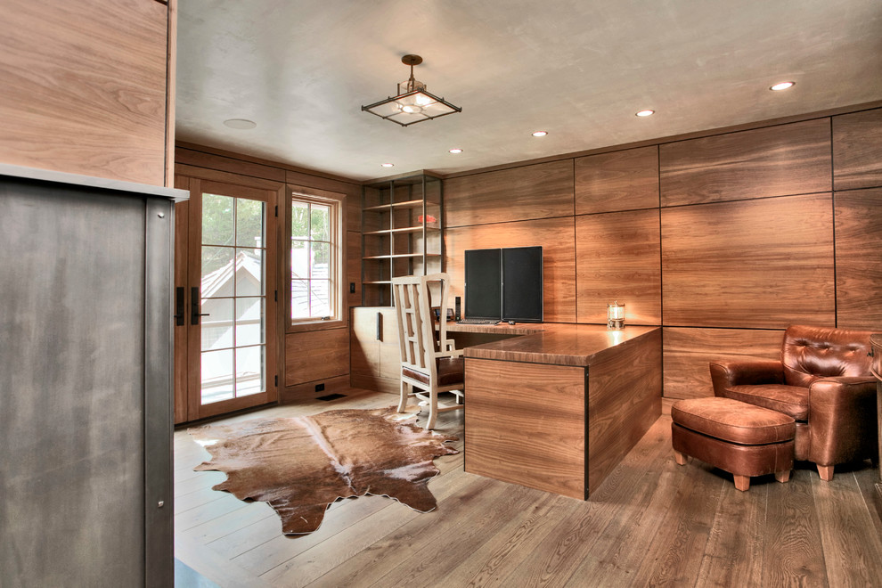 Großes Modernes Arbeitszimmer mit brauner Wandfarbe, braunem Holzboden, Kamin, Kaminumrandung aus Metall, Einbau-Schreibtisch und braunem Boden in New York