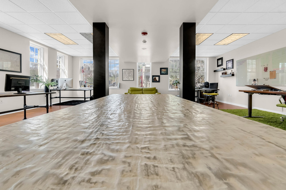 Medium sized industrial home studio in Orlando with white walls, vinyl flooring, a freestanding desk and beige floors.