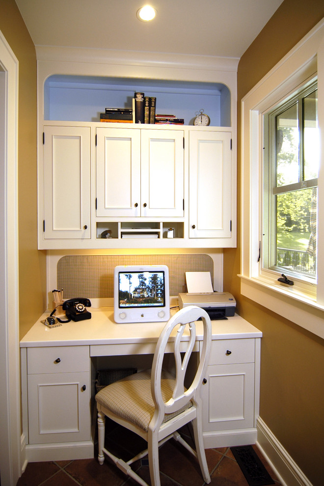 Imagen de despacho clásico grande con paredes beige, suelo de baldosas de cerámica y escritorio empotrado
