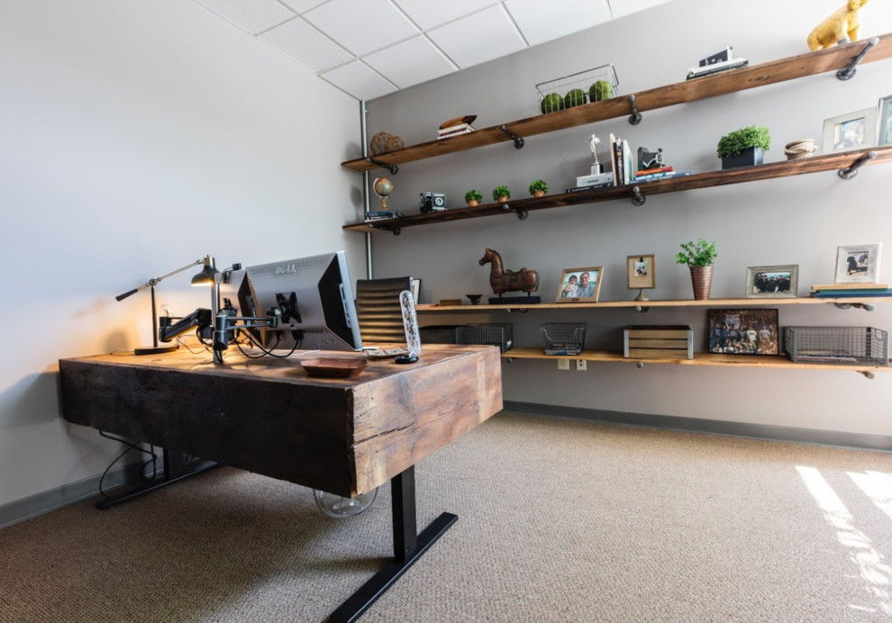 Diseño de despacho industrial con paredes grises, moqueta y escritorio independiente