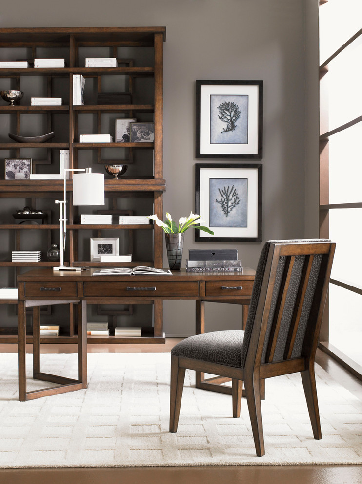 Modelo de despacho clásico grande sin chimenea con paredes beige, suelo de madera en tonos medios y escritorio independiente