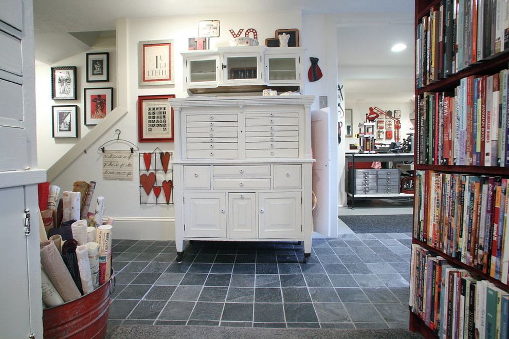 На фото: огромная домашняя мастерская в стиле лофт с белыми стенами, бетонным полом и отдельно стоящим рабочим столом без камина
