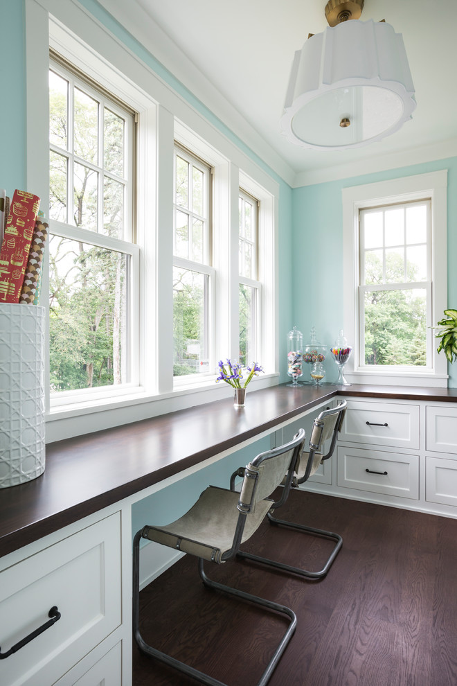 This is an example of a classic study in Other with blue walls, dark hardwood flooring and brown floors.