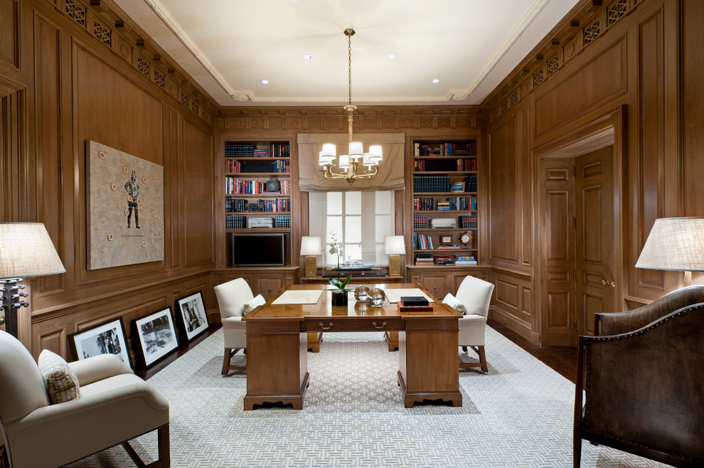 Inredning av ett klassiskt stort hemmabibliotek, med bruna väggar, heltäckningsmatta och ett fristående skrivbord