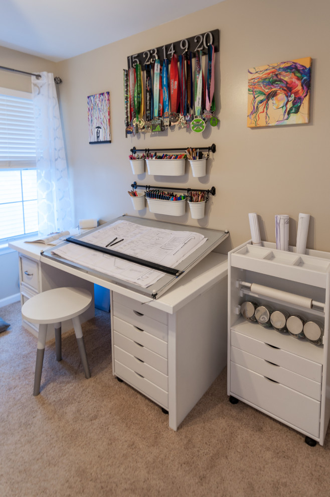 Modern inredning av ett mellanstort hemmastudio, med beige väggar, heltäckningsmatta och ett fristående skrivbord