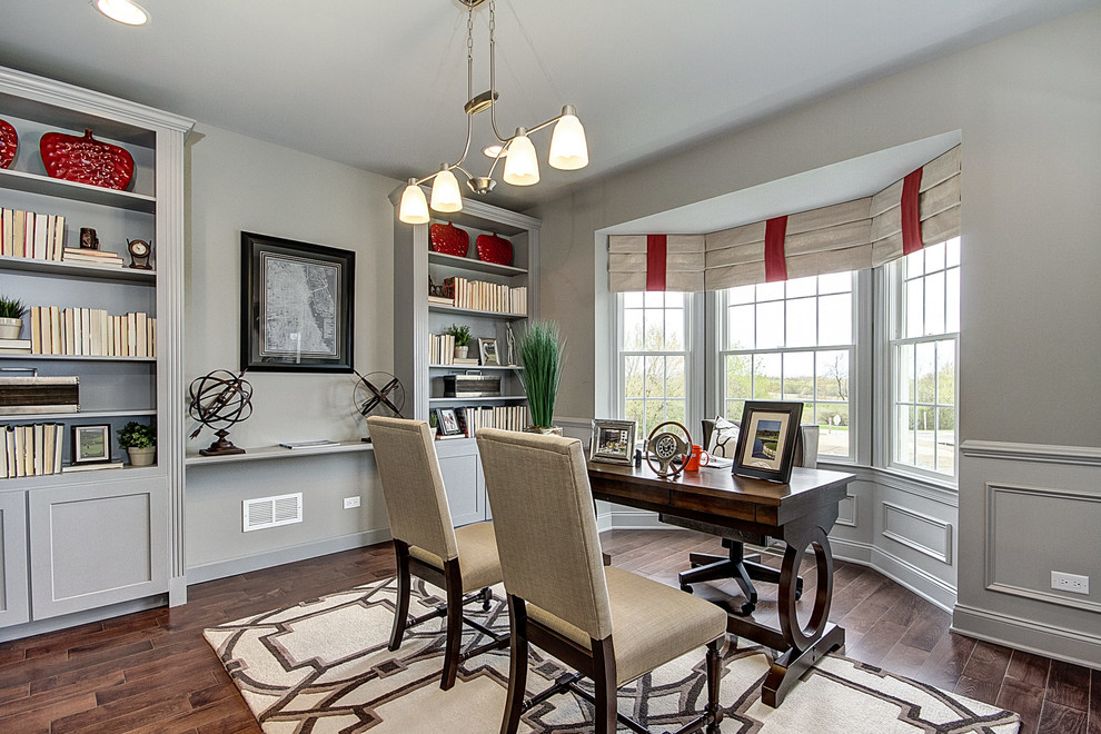 Transitional freestanding desk medium tone wood floor study room photo in Chicago with gray walls