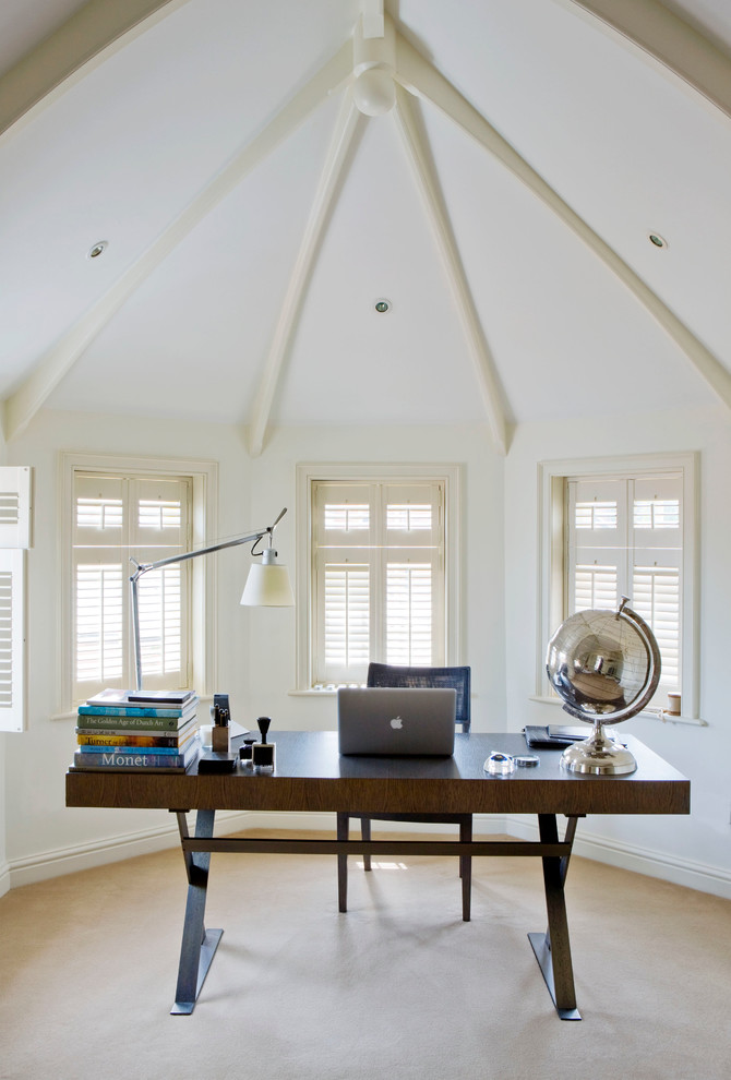 Klassisches Arbeitszimmer mit weißer Wandfarbe, Teppichboden und freistehendem Schreibtisch in Sonstige