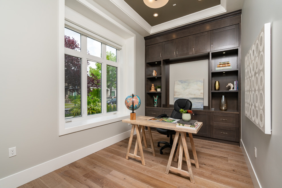 Imagen de despacho contemporáneo de tamaño medio con paredes grises, suelo de madera en tonos medios, escritorio independiente y suelo marrón