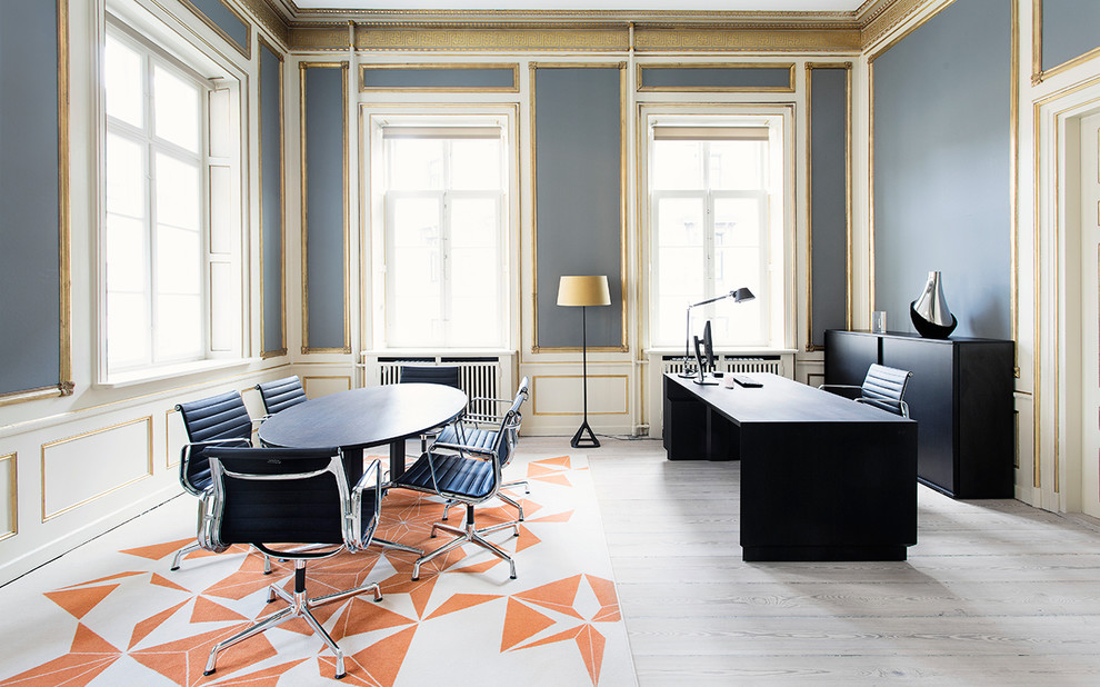 Ejemplo de despacho escandinavo grande con paredes azules, suelo de madera clara y escritorio independiente