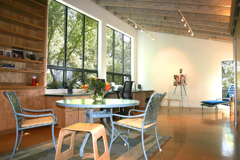 Стильный дизайн: маленькое рабочее место в стиле модернизм с белыми стенами, пробковым полом и встроенным рабочим столом для на участке и в саду - последний тренд
