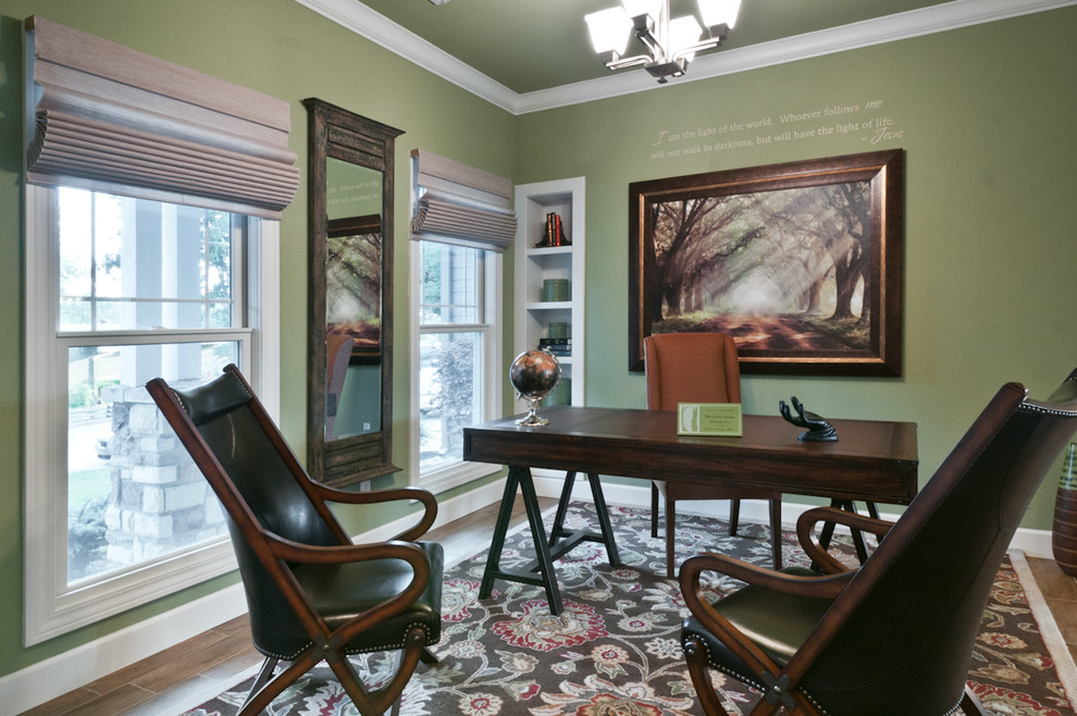 Immagine di uno studio stile americano di medie dimensioni con pareti verdi, parquet scuro e scrivania autoportante
