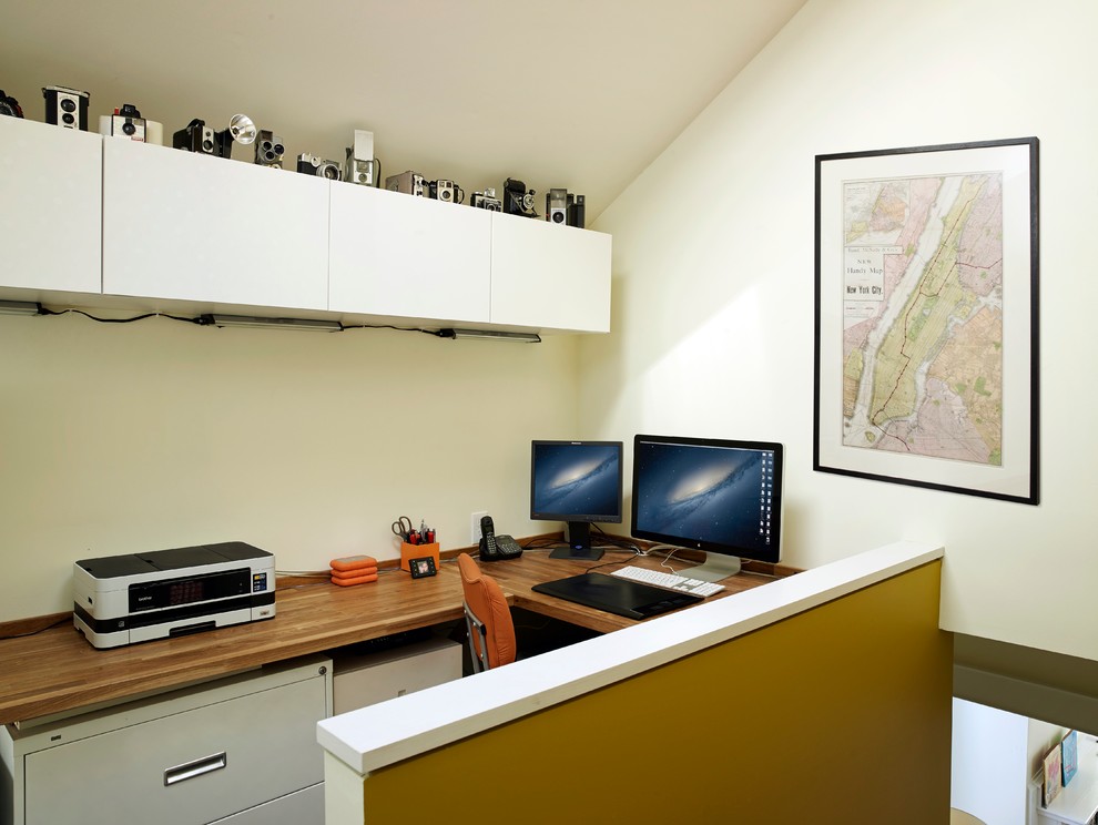Immagine di uno studio eclettico con pareti bianche e scrivania incassata