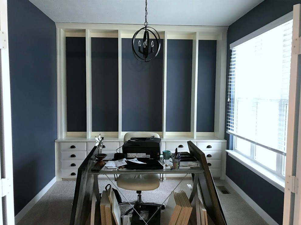 Cette photo montre un grand bureau tendance avec un mur bleu.