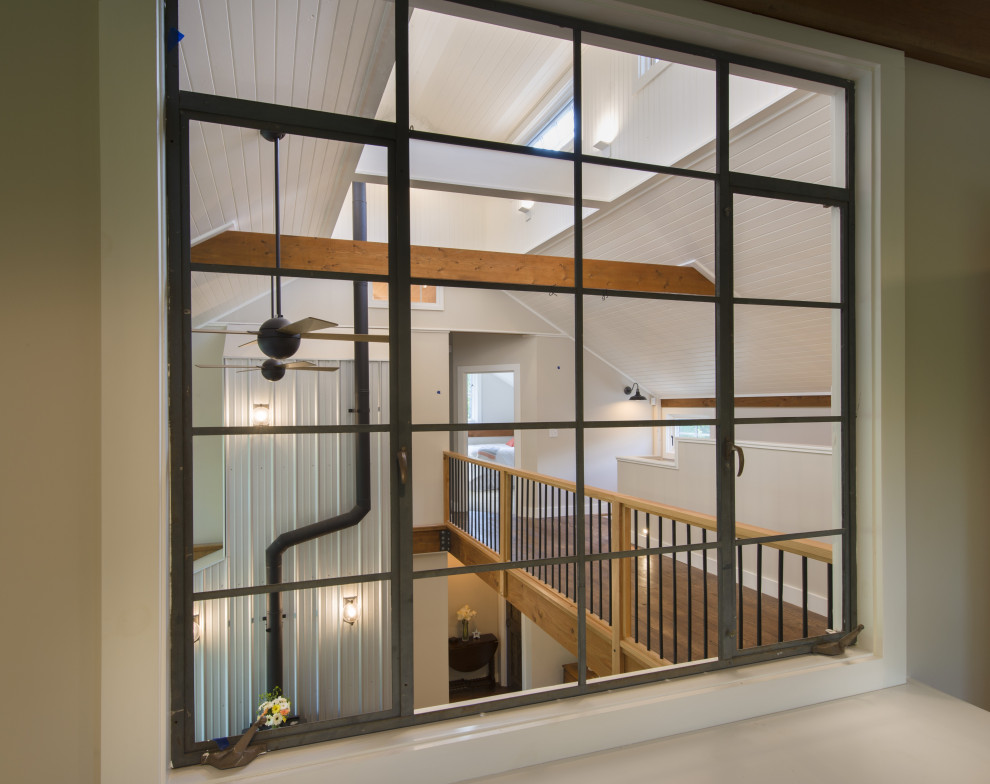 Foto de estudio de estilo de casa de campo con paredes blancas, suelo de madera en tonos medios y suelo marrón