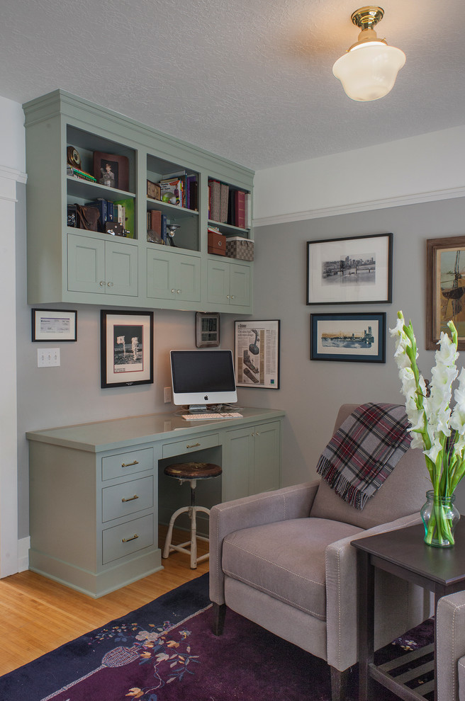 Réalisation d'un petit bureau craftsman avec un mur gris, parquet clair et un bureau intégré.