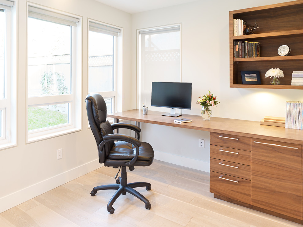 Ejemplo de despacho contemporáneo pequeño sin chimenea con paredes blancas, suelo de madera clara, escritorio empotrado y suelo marrón