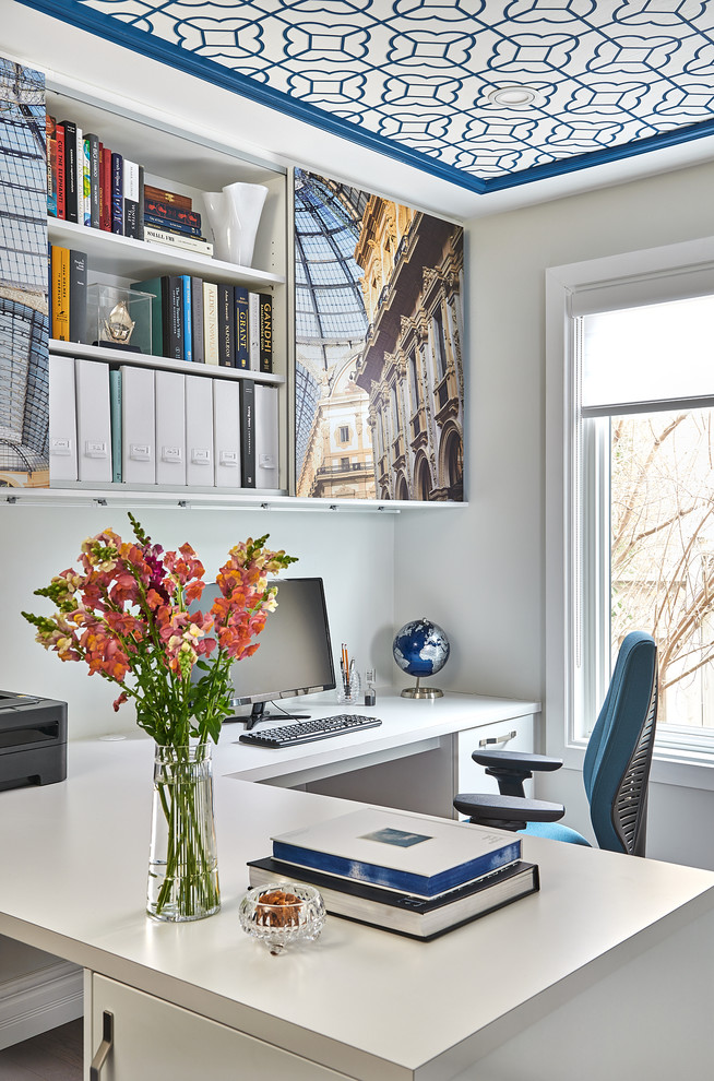 Foto de despacho clásico renovado de tamaño medio sin chimenea con paredes blancas, suelo de madera en tonos medios, escritorio empotrado y suelo marrón