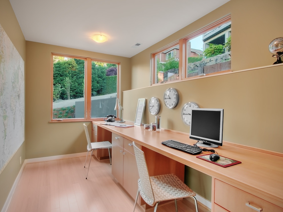 Modernes Arbeitszimmer mit braunem Holzboden und Einbau-Schreibtisch in Seattle