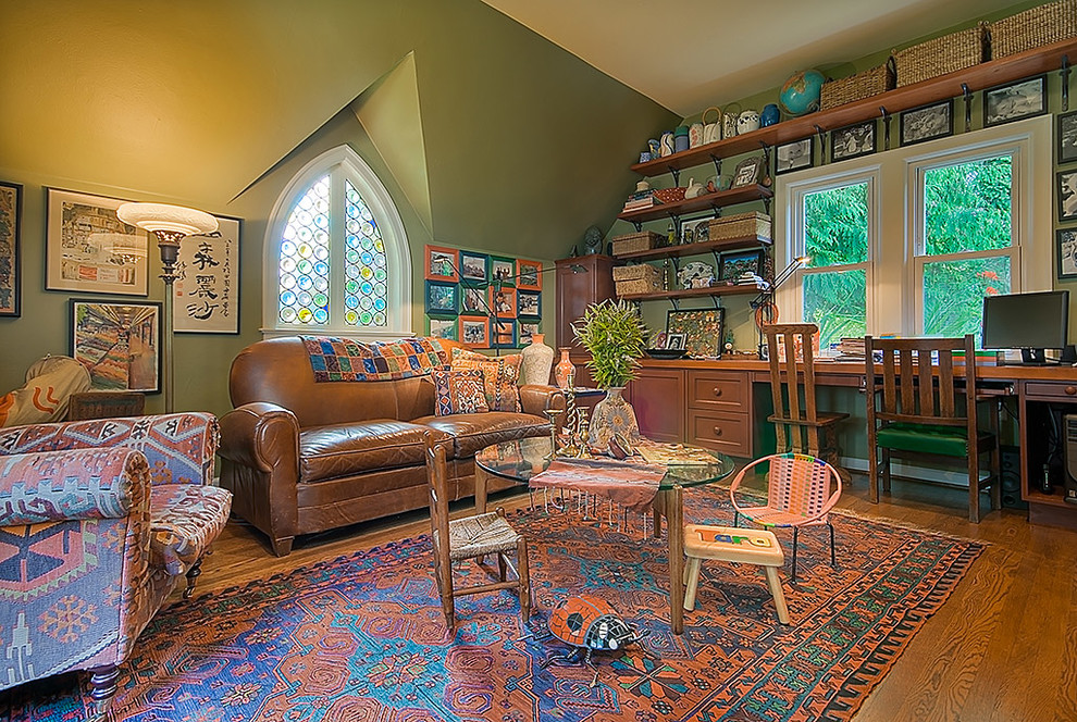 Großes Klassisches Arbeitszimmer ohne Kamin mit Arbeitsplatz, grüner Wandfarbe, braunem Holzboden, freistehendem Schreibtisch und braunem Boden in Seattle