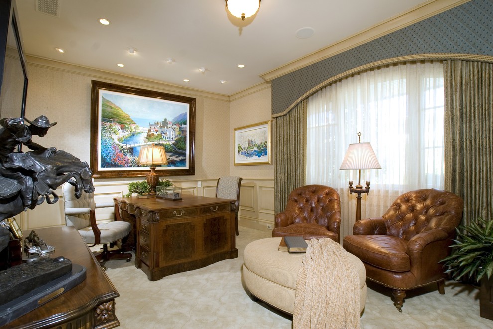 На фото: кабинет в классическом стиле с бежевыми стенами, ковровым покрытием и отдельно стоящим рабочим столом с