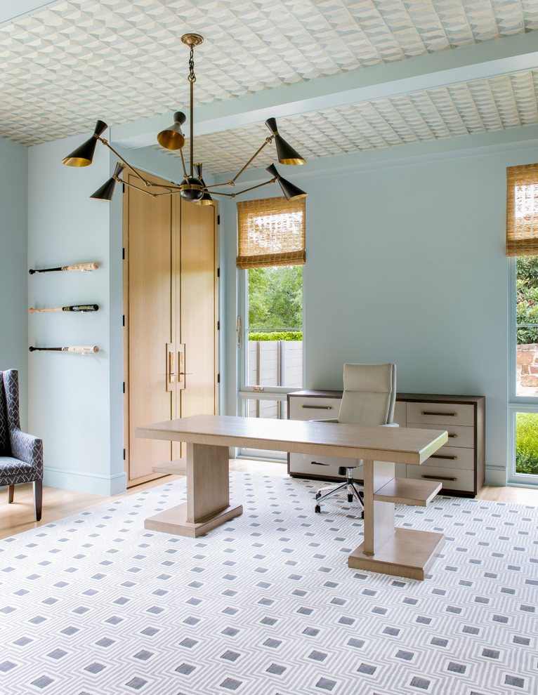 Foto de despacho mediterráneo grande con paredes azules, suelo de madera clara y escritorio independiente