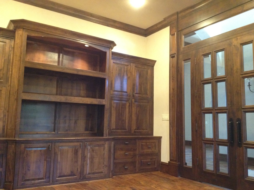 Ejemplo de despacho mediterráneo grande sin chimenea con paredes beige, suelo de madera oscura y escritorio empotrado