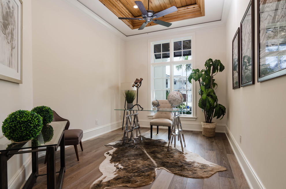 Foto de despacho clásico renovado de tamaño medio sin chimenea con paredes beige, suelo de madera en tonos medios, escritorio independiente y suelo marrón