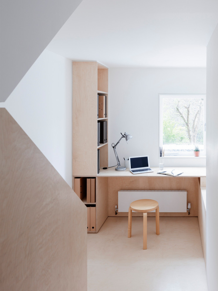 Inredning av ett modernt arbetsrum, med vita väggar, ett inbyggt skrivbord och beiget golv