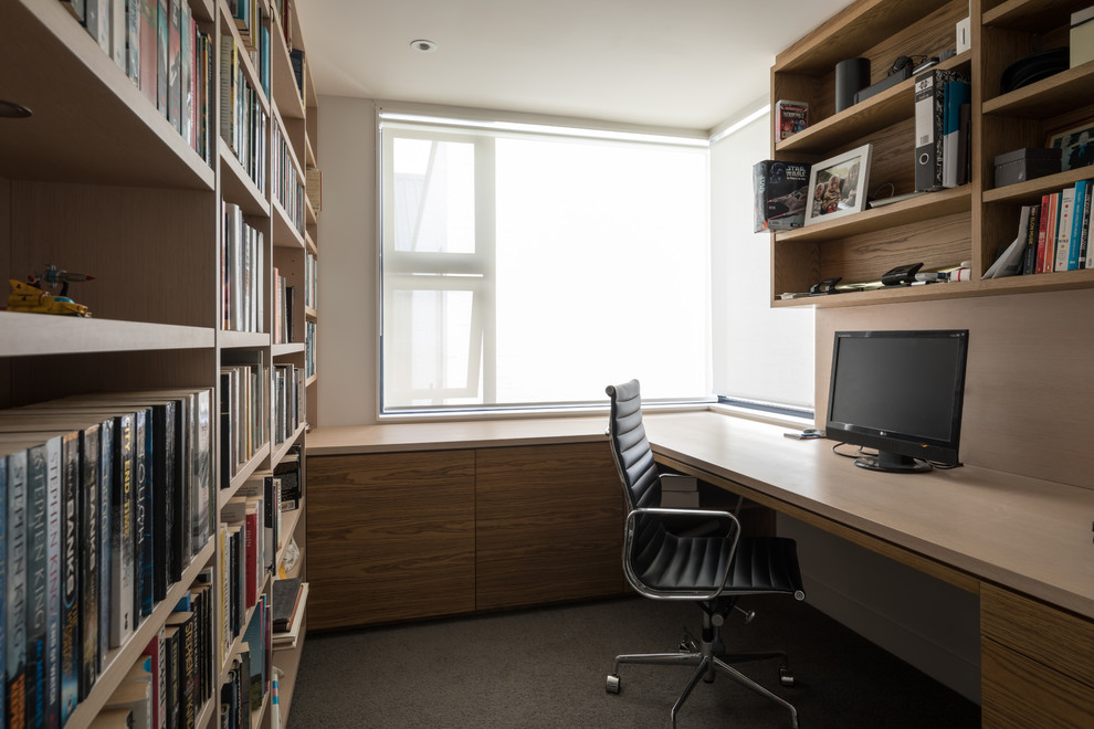 Cette image montre un bureau design avec un mur beige, un bureau intégré et un sol gris.