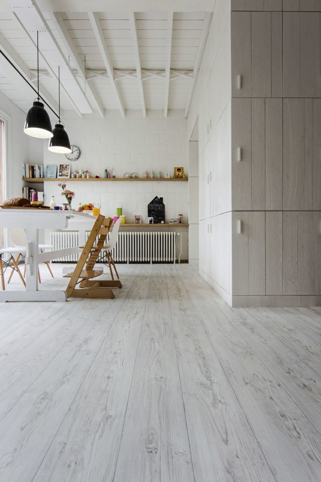 This is an example of a large contemporary craft room in Toronto with white walls, lino flooring, no fireplace, a freestanding desk and white floors.