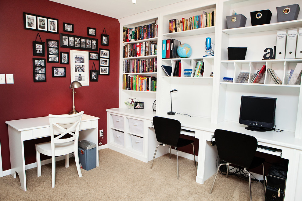 На фото: кабинет среднего размера в стиле неоклассика (современная классика) с красными стенами, встроенным рабочим столом, ковровым покрытием и коричневым полом без камина