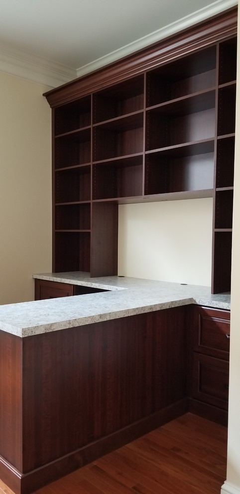Ejemplo de despacho tradicional de tamaño medio con paredes amarillas, suelo de madera en tonos medios, escritorio empotrado y suelo marrón